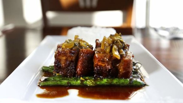 Pork ribs with caramelised sweet and sour soy glaze with round beans and mustard leaves, at Morks.