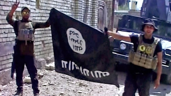 Iraqi troops turn the Islamic State flag upside down after liberating Fallujah from the terrorist group.