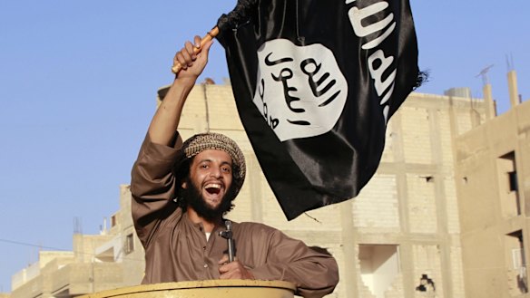 Accentuating the positive: a man waves an IS flag in streets of Syria's north-eastern Raqqa province. 