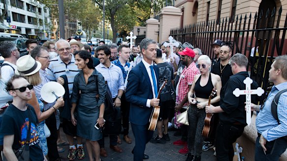 A protester holds a "R.I.P. Live Music" sign at the NSW Parliament to protest the closure of famed live music venue The Basement. 