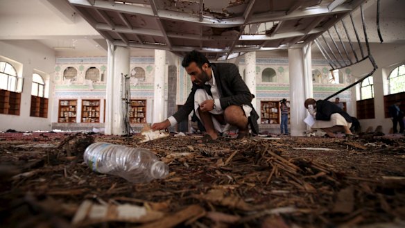 Investigators examine the scene after a suicide bomb attack at a mosque in Sanaa on Friday.