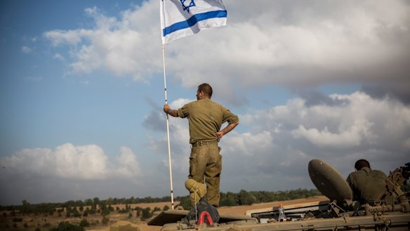 An Israeli soldier stands on top of an armoured personnel carrier near the Israel-Gaza Strip border during Operation Protective Edge in July 2014.
