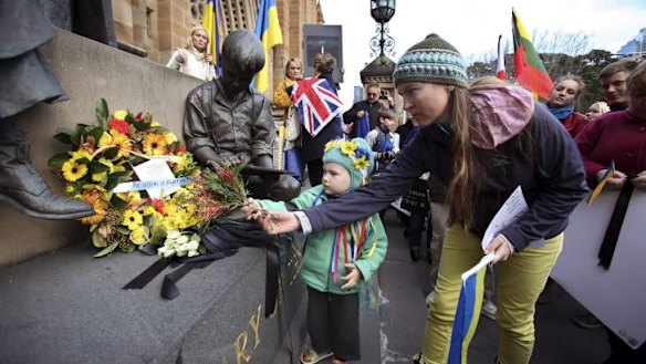 Ukrainian Community placing a reef of flowers and black ribbons at the Mary MacKillop Memorial, St Mary Cathedral in Sydney.