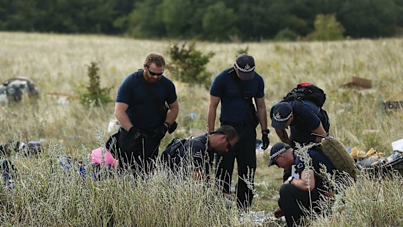 Australian Federal Police officers and their Dutch counterparts collect human remains from the MH17 crash site. 
