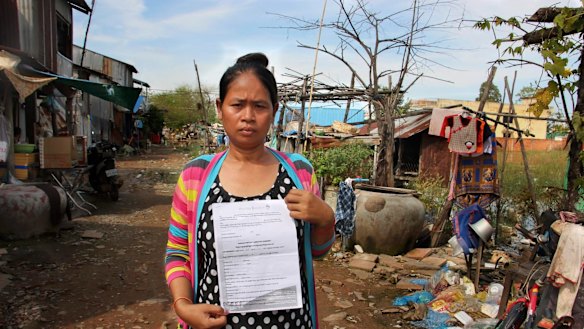Cambodian surrogate mother Hour Vanny, holding the two-page document she signed with Fertility Solutions, operated by Australian nurse Tammy Davis-Charles. 