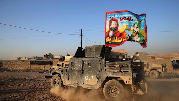 An Iraqi special forces vehicle carries a Shiite flag near Mosul in November.