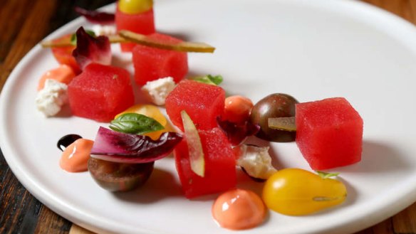 A delicate dish of watermelon, feta, heirloom tomatoes and basil.