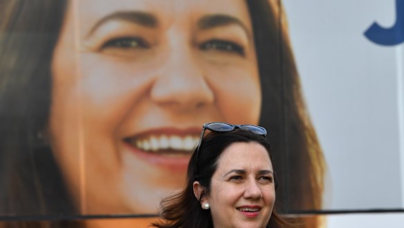 Queensland Premier Annastacia Palaszczuk is seen standing next to the media bus.
