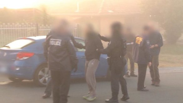 Australian Federal Police arrest a man during a raid on an Islamic store in Logan, south of Brisbane. 