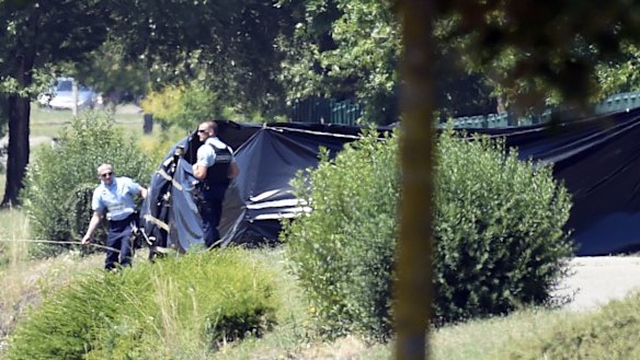 French police erect tents to enclose the area where a decapitated body was found.