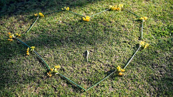 A heart-shaped chain of yellow and orange jonquils at the scene of the woman's death in Princes Park.