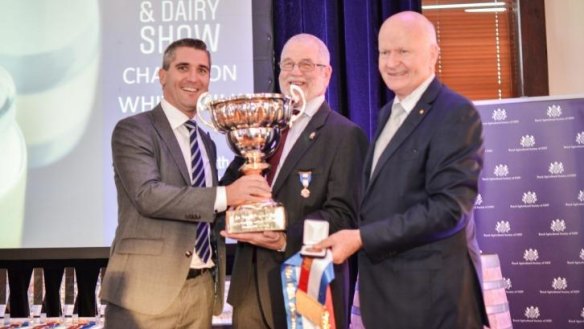 Robert Ryan OAM, president of the Royal Agricultural Sociey of NSW, and Mark Livermore, chair of judges of the show, present the Champion White Milk award to Nicholas Bond, buying director of Aldi, for its Farmdale Full Cream Milk.