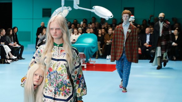 A model carries a fake head as she wears a creation as part of the Gucci women's Fall/Winter 2018-2019 collection, presented during the Milan Fashion Week.