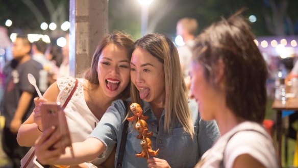 Friends pull faces for a selfie at the Night Noodle Markets in 2016.