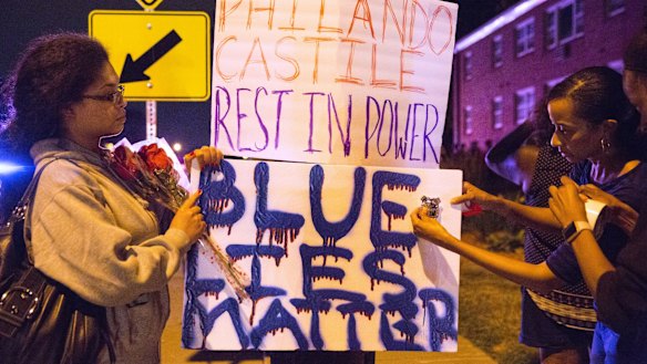 Protesters hang signs near the scene of Philando Castile's shooting.