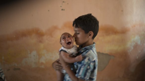 Ten-year-old Elison nurses his 2-month-old brother Jose Wesley, who was born with microcephaly, at their house in Brazil. 