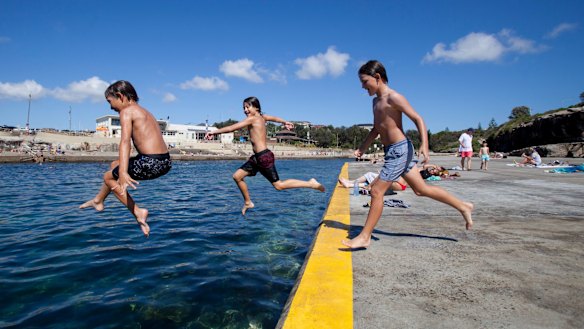 Crossing the line: (left to right) 10 year olds Bodie Taylor, Arki George, and Frankie Parsons jump in the ocean at Clovelly.