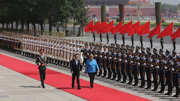 Chinese Premier Li Keqiang escorts  German Chancellor Angela Merkel past the People's Liberation Army honour guards to welcome her to China on Thursday.