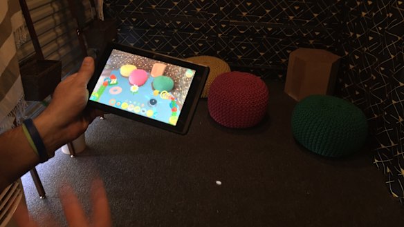 A corner full of colourful cushions comes to life with interactive virtual toys on the screen.
