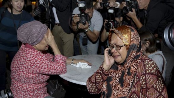 Relatives of a passenger on board Malaysia Airlines flight  MH17 are surrounded by media.