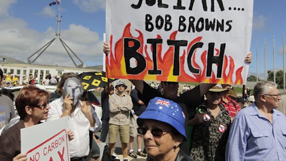 Getting personal ... protesters wave placards at the No Carbon Tax rally outside Parliament House in Canberra.
