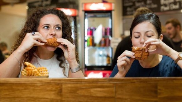 Diners at Thirsty Bird tuck into fried chicken and waffle fries.