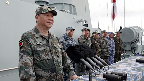 Chinese President Xi Jinping, left, prepares to address the troops after reviewing the People\'s Liberation Army Navy fleet in the South China Sea. 