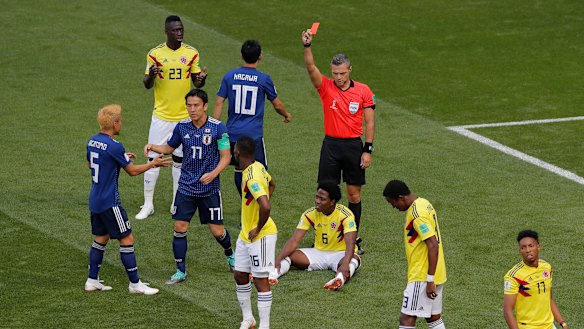 Take a walk: Referee Damir Skomina shows a red card to Colombia's Carlos Sanchez, who is sitting on the ground.