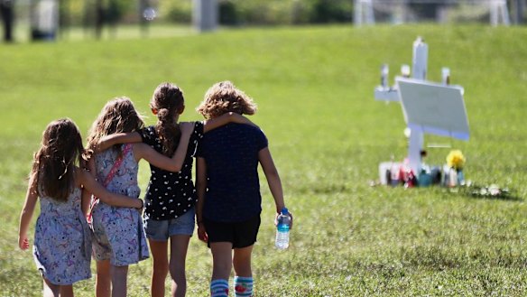 Four children console each other after 17 students were killed by a former student at Marjory Stoneman Douglas High School in Parkland, Florida.