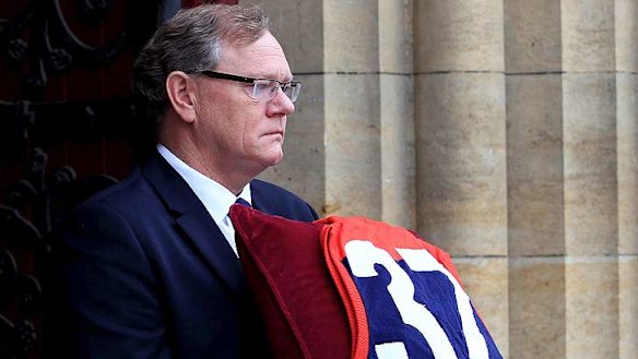 Demons President Don McLardy carries Stynes' treasured jumper from the service.