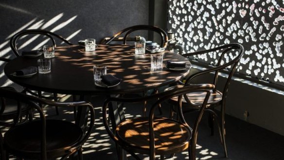 A screen at the window throws dappled light on the front table at IDES.