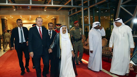 Turkish President Recep Tayyip Erdogan, second left, walks with the Emir of Kuwait Sheikh Sabah al-Ahmad al-Sabah, center, prior to their meeting in Kuwait City on Sunday.