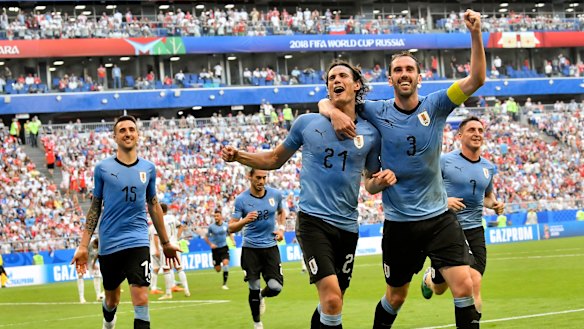 Uruguay's Edinson Cavani, centre, celebrates notching the third goal with teammate Diego Godin.