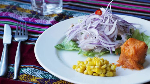 Peruvian fish ceviche is hidden under a hill of red onion.