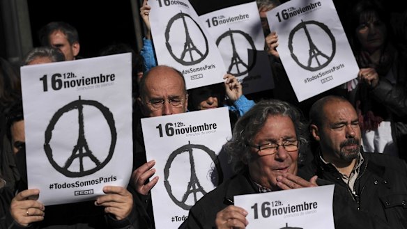 Members of Spanish trade unions hold up banners that read ''November 16. We Are All Paris'' as they stand during a minute of silence for victims of the Paris attack.