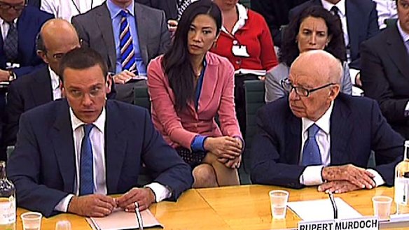 Protective ... Wendi Deng watches her husband before the incident.