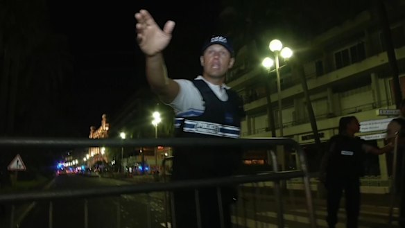 A policeman chase people out of the cordoned-off area.