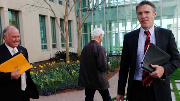 Portentous? ... Bob Katter walks away from a media conference with Tony Windsor (left) and Rob Oakeshott (right) yesterday.