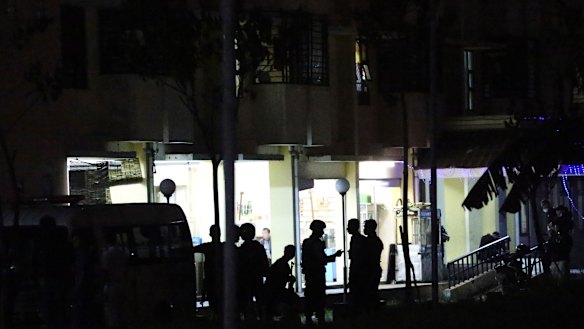 Indonesian police stand guard in front of an apartment building after an explosion. 