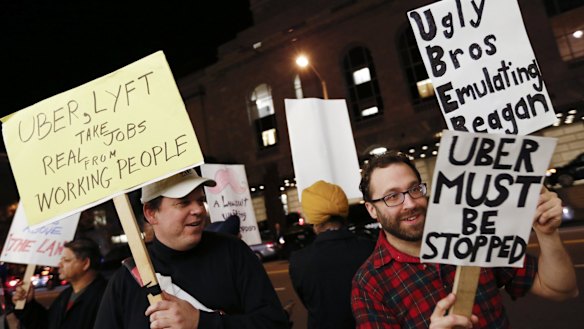 Demonstrators hold signs during a protest organised by the San Francisco Taxi Workers Alliance.