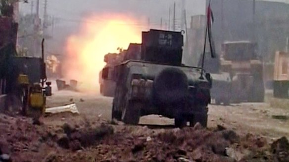 A tank opens fire during clashes in Fallujah on Sunday.