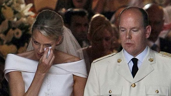 All white ... Princess Charlene dries her eyes as she and husband Prince Albert leave their marriage blessing.