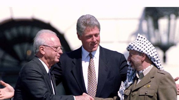 Yasser Arafat and Yitzhak Rabin shaking hands at the White House signing ceremony of the Oslo Accords in 1993, watched by President Bill Clinton.
