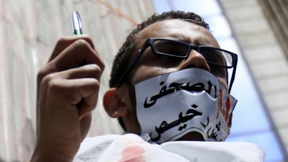 Dissent stifled: An Egyptian journalist protests against the country's Interior Ministry, which is accused of targeting journalists. The tape across his mouth reads "the blood of a journalist is not cheap".