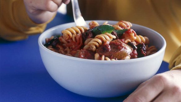 Spiral pasta with sausage, tomato and olives.