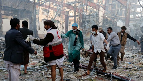 Medics carry the body of a victim of a Saudi-led coalition airstrike in Sanaa, Yemen.