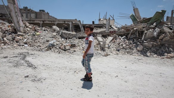 A boy walks past destroyed buildings in the Syrian town of Kobane.