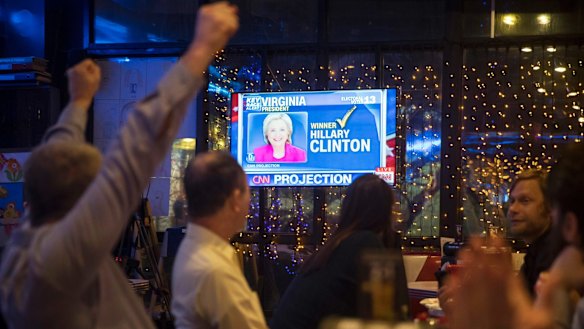 Andrew Hardisty of the US, left, and other people react as they watch a live telecast of the US presidential election in a cafe in Moscow.
