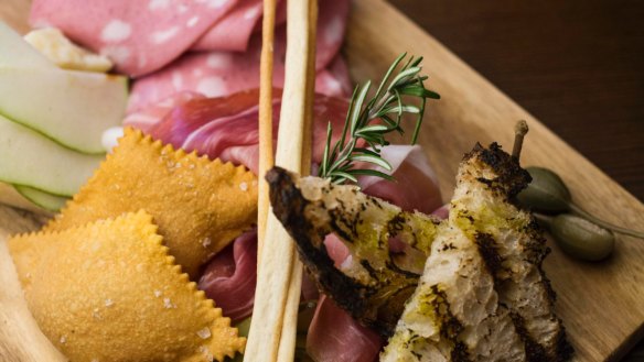 A charcuterie platter featuring mortadella and gnocco fritto.