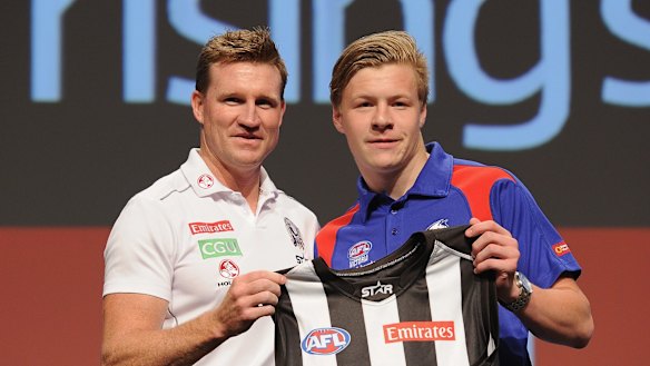 Jordan De Goey receives his jumper from coach Nathan Buckley.
